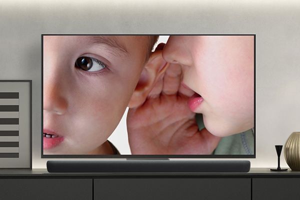 TV showing little boy whispering into the ear of another little boy